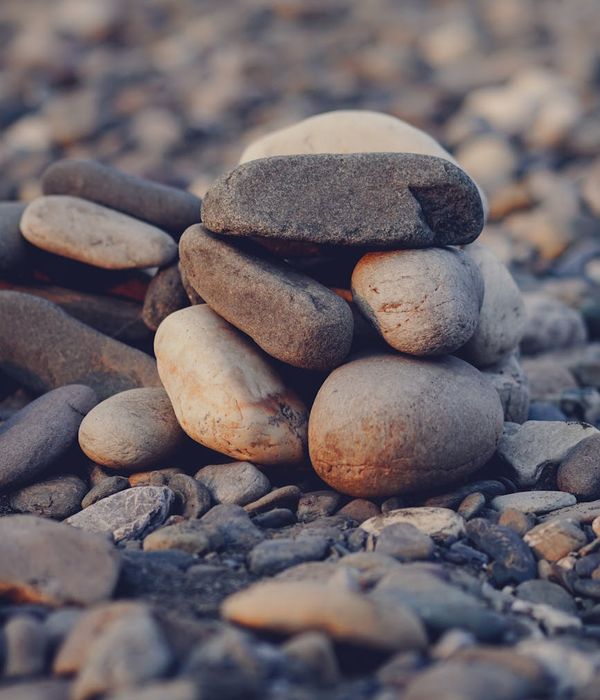 A balanced stack of smooth stones on a wooden surface, symbolizing harmony.