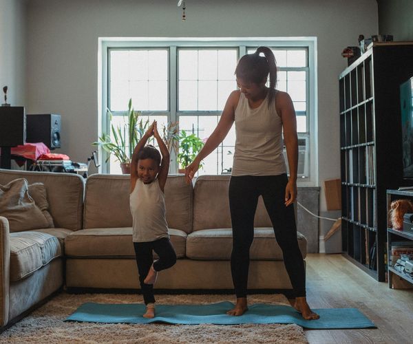 A cozy and tidy corner for home yoga practice with a mat, candles, and a plant.